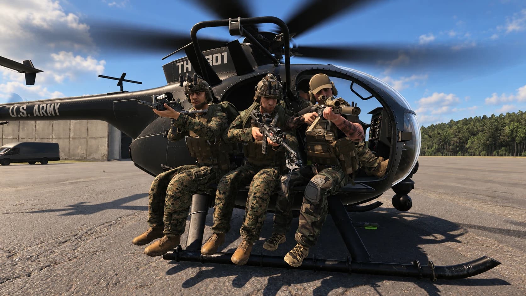 Task force members seated on a Little Bird helicopter